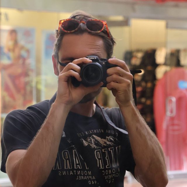 Bastien photographing himself in a shop window
